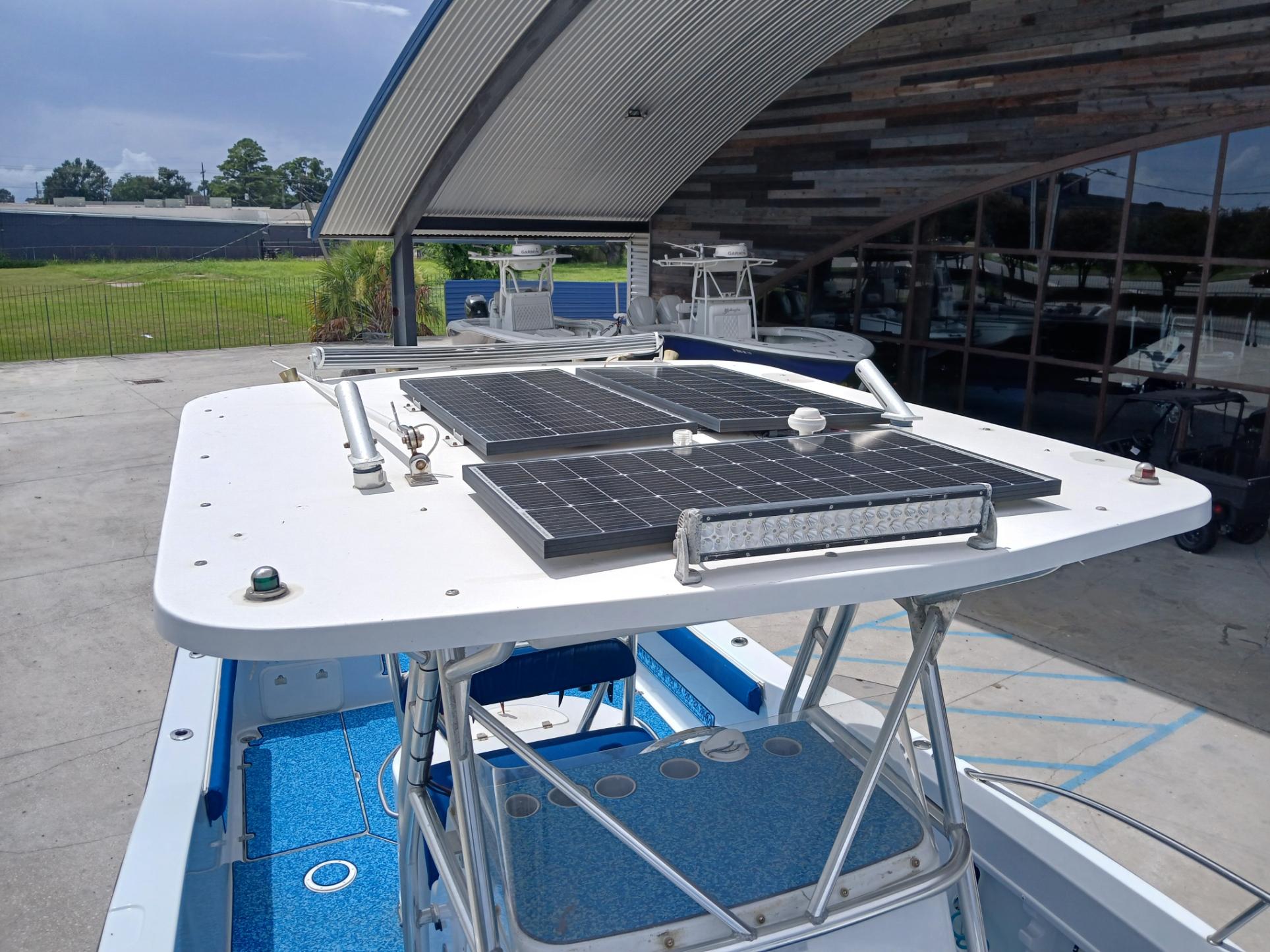 2002 ProKat 2860 Center Console with solar panels on the roof, docked outdoors.