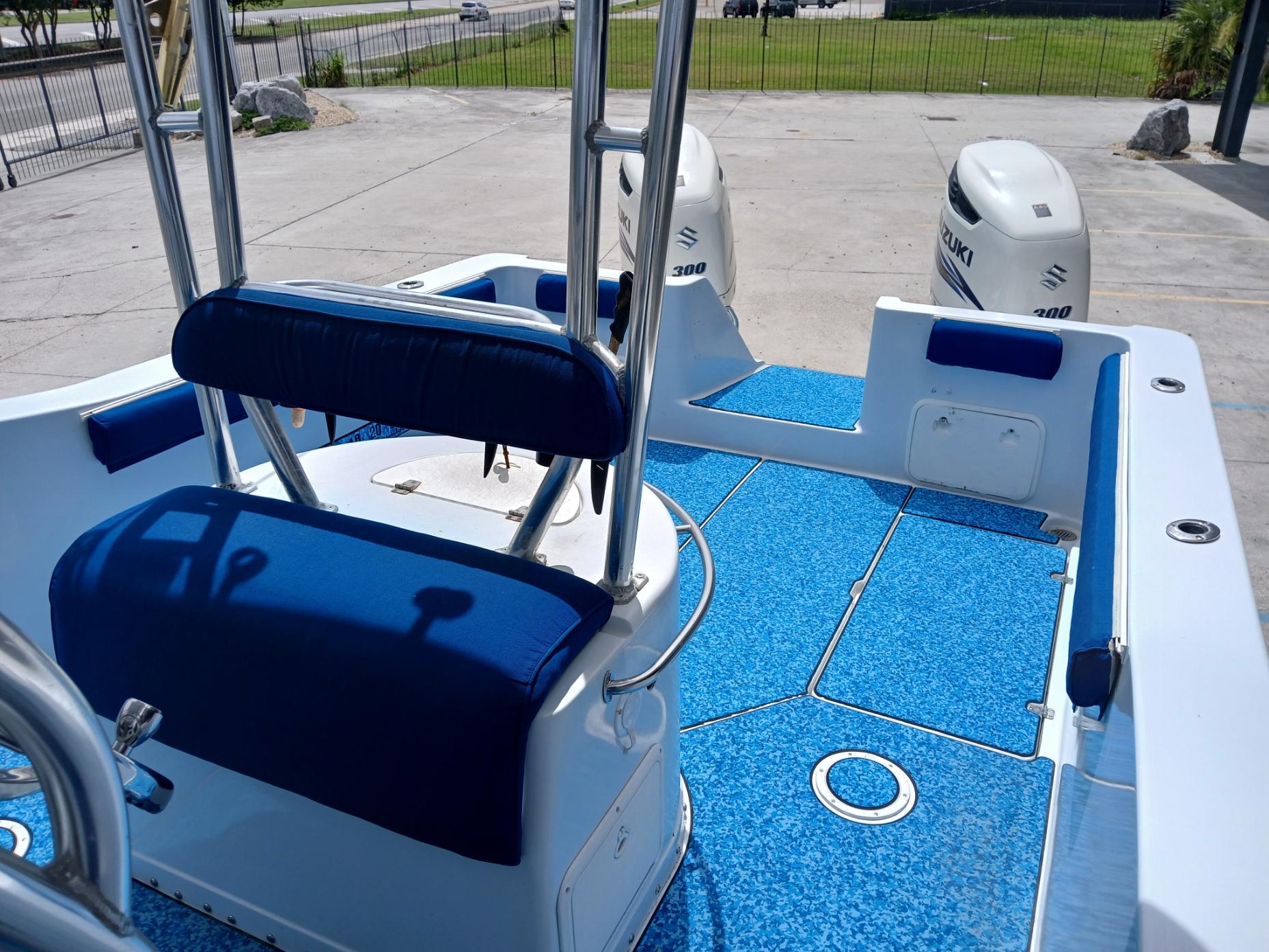 2002 ProKat 2860 Center Console boat with blue seating and twin Suzuki engines.