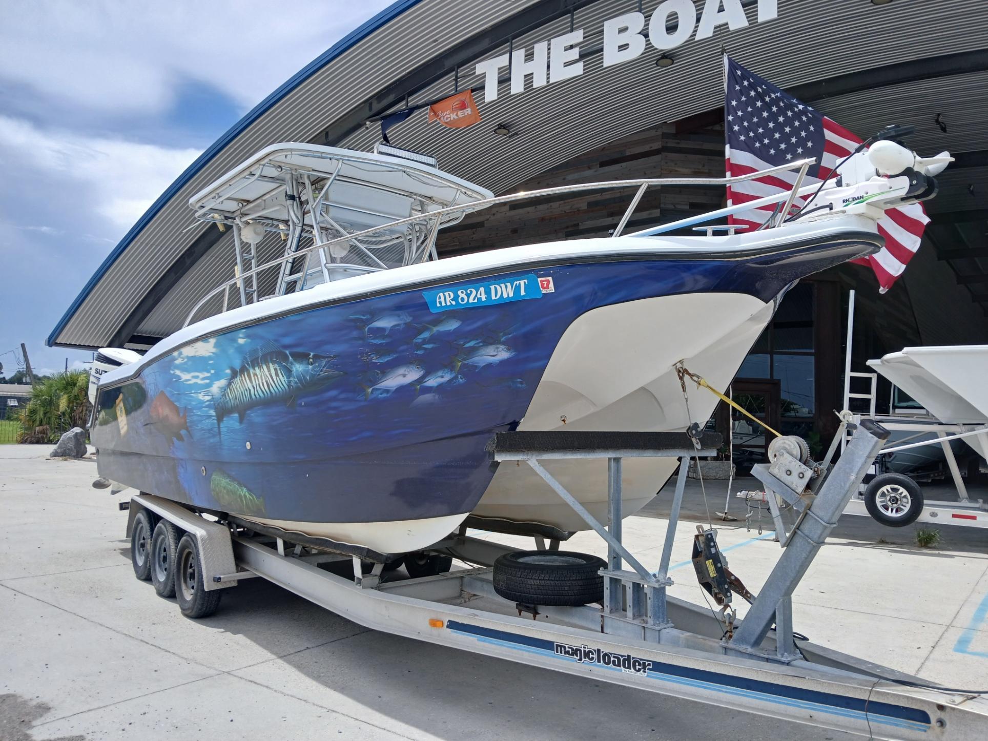 2002 ProKat 2860 Center Console boat on trailer, featuring marine-themed hull artwork.