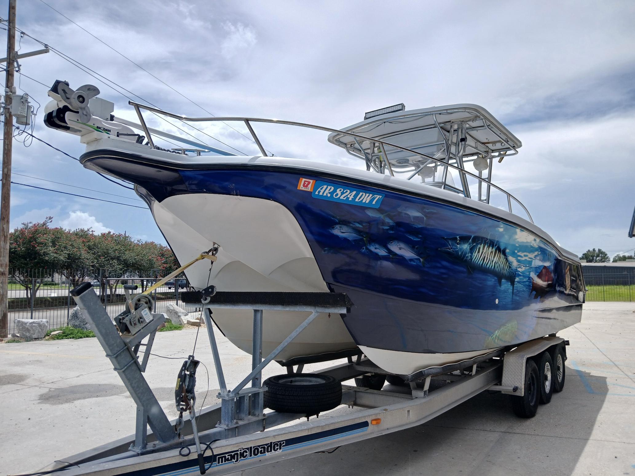 2002 ProKat 2860 Center Console boat on trailer, featuring marine-themed hull artwork.