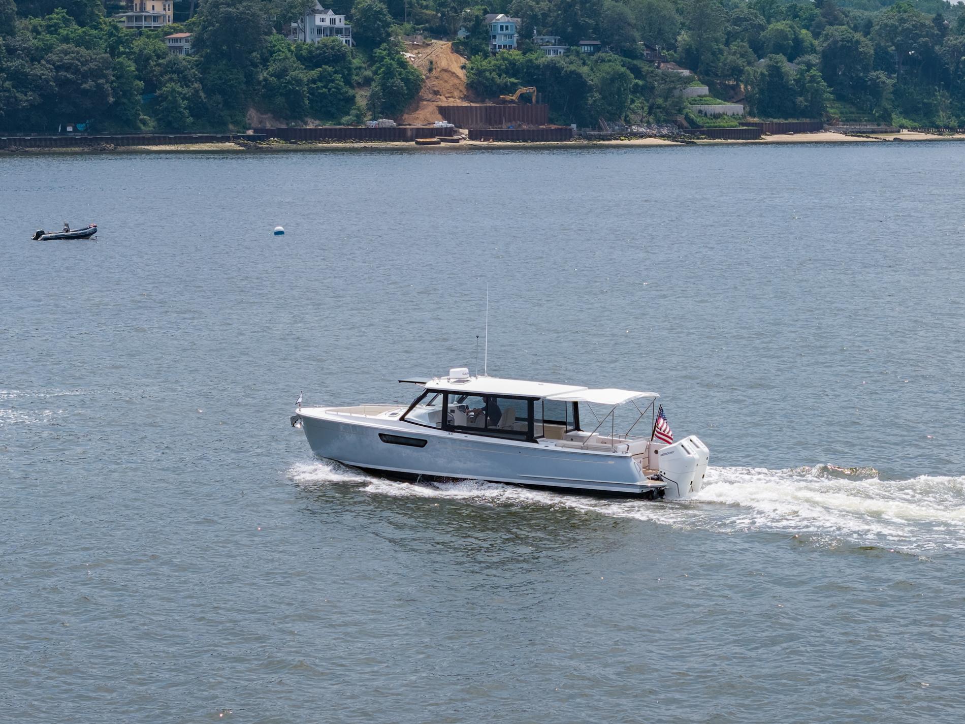 MJM 3 boat cruising on a scenic river, 2025 model.