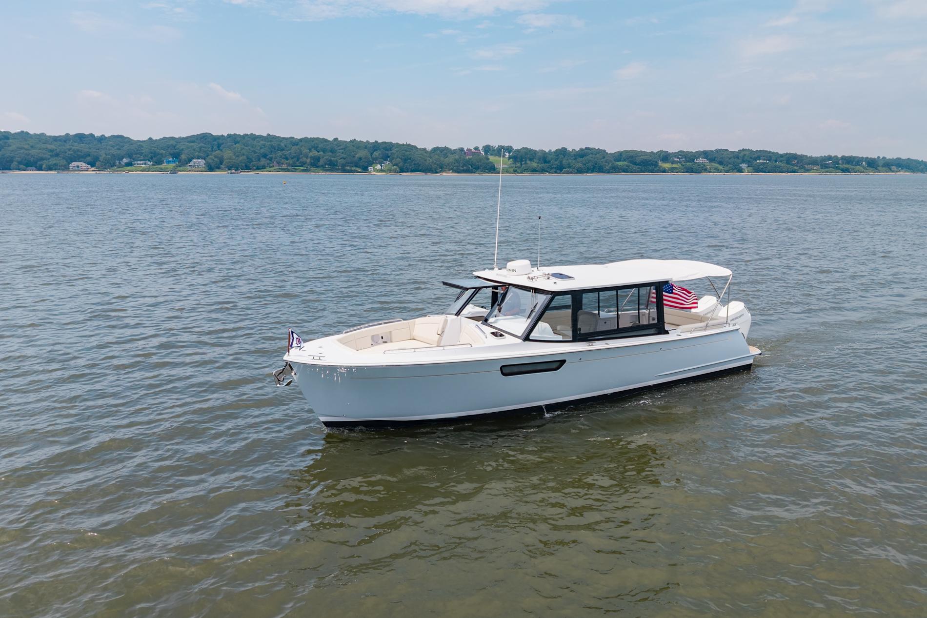 2025 MJM 3 boat cruising on a calm lake under a clear sky.