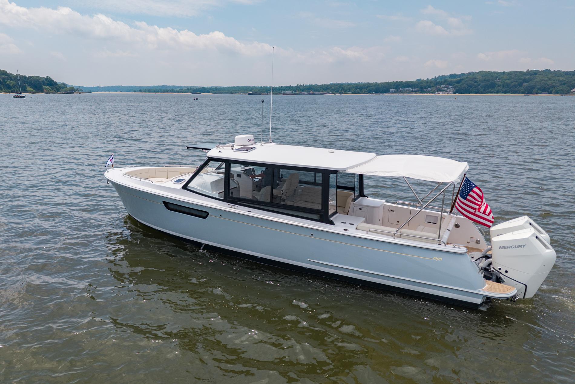 2025 MJM 3 boat on calm water, featuring sleek design and American flag.