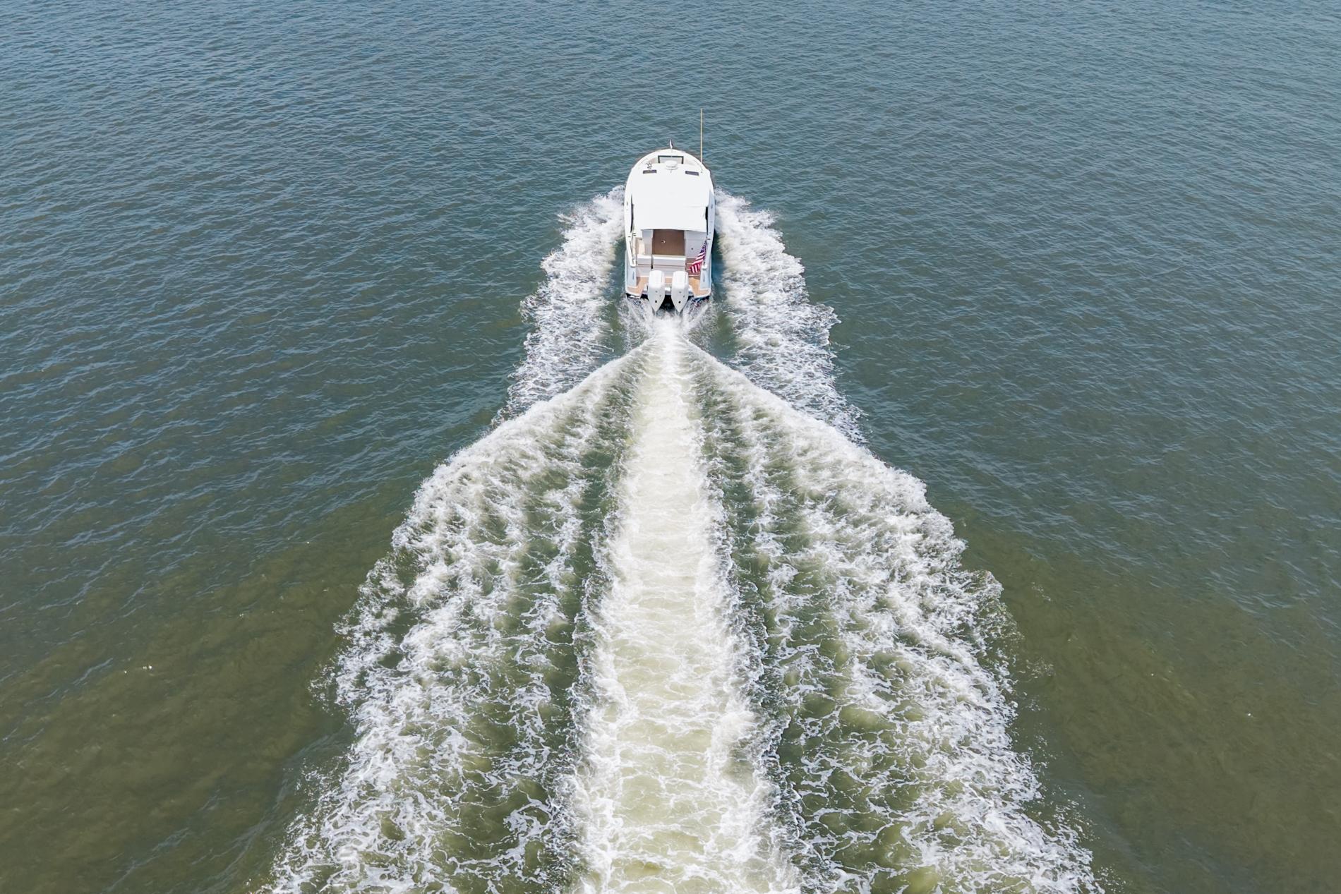 Aerial view of 2025 MJM 3 boat cruising on open water, leaving a wake.