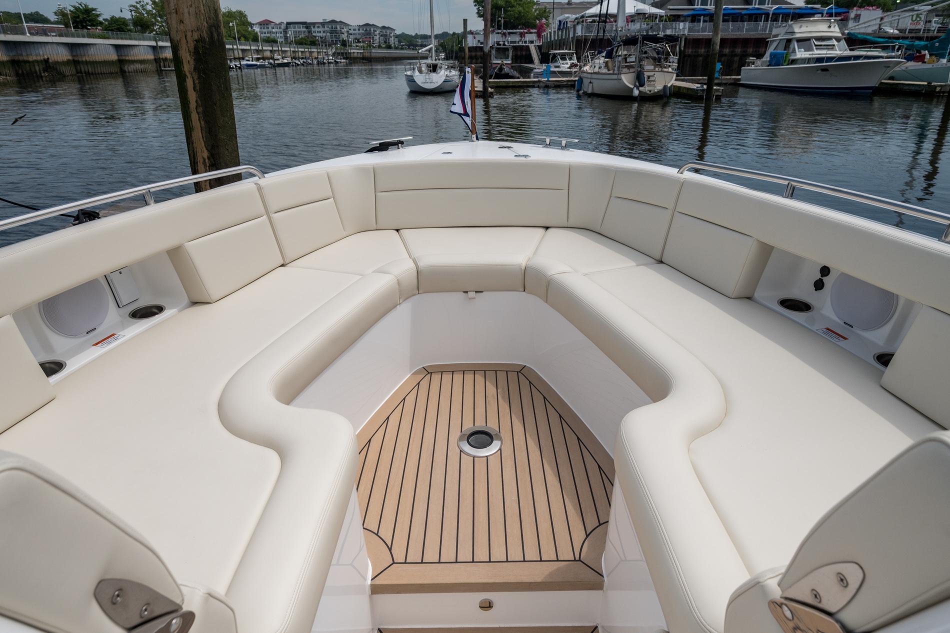 Luxurious seating area on 2025 MJM 3 boat, docked at a marina.
