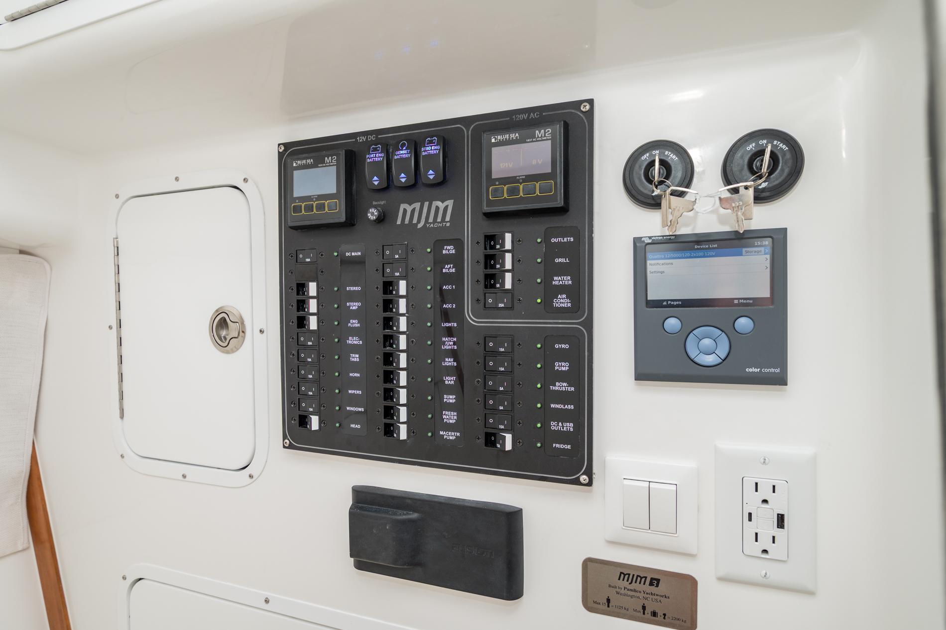 Electrical control panel on 2025 MJM 3 yacht, featuring switches and digital displays.