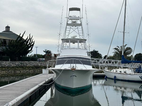 1988 Buddy Davis Convertible yacht docked at marina, front view with calm water reflection.