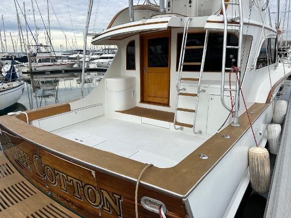 1988 Buddy Davis Convertible yacht docked at marina, featuring spacious deck and wooden accents.