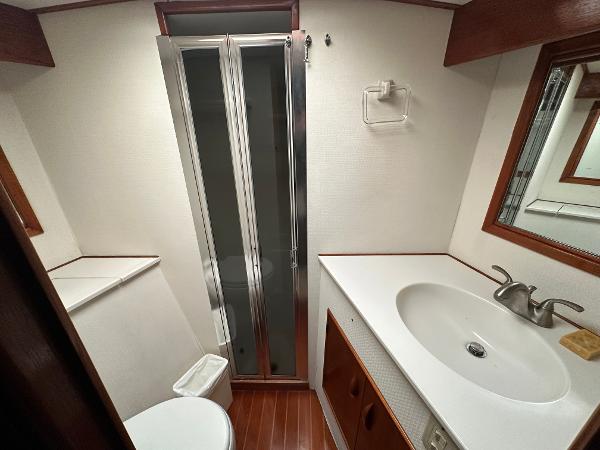 1988 Buddy Davis Convertible yacht bathroom with shower, sink, and wooden accents.