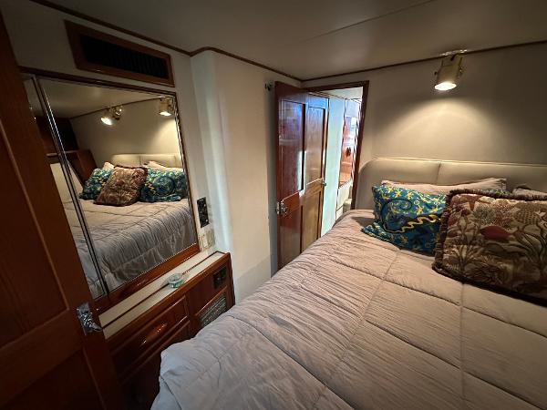 Cozy bedroom in 1988 Buddy Davis Convertible yacht with plush bedding and mirrored closet.
