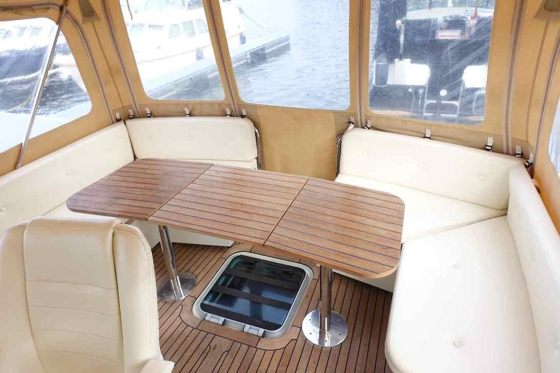 Luxurious interior of 2014 Linssen Grand Sturdy 40.9 AC yacht with wooden table and seating.