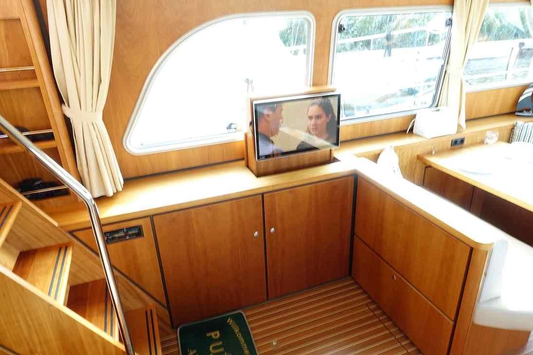 Interior of 2014 Linssen Grand Sturdy 40.9 AC yacht with wooden cabinetry and TV.