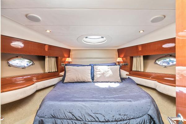Luxurious cabin interior of 2007 Viking Sport Cruiser with cozy bed and elegant wood finish.