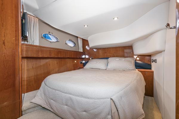2007 Viking Sport Cruiser bedroom with cozy bed and wooden interior design.