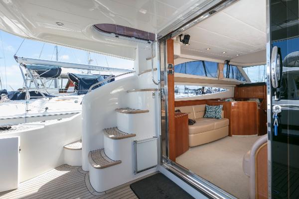 2007 Viking Sport Cruiser interior with elegant seating and spiral staircase, docked at marina.