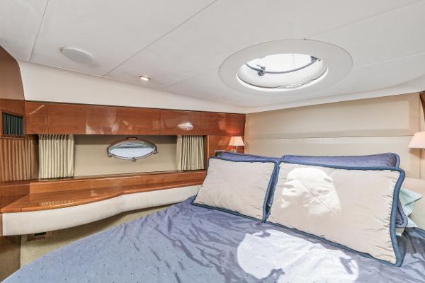 Luxurious cabin interior of a 2007 Viking Sport Cruiser yacht with elegant bedding and wood accents.