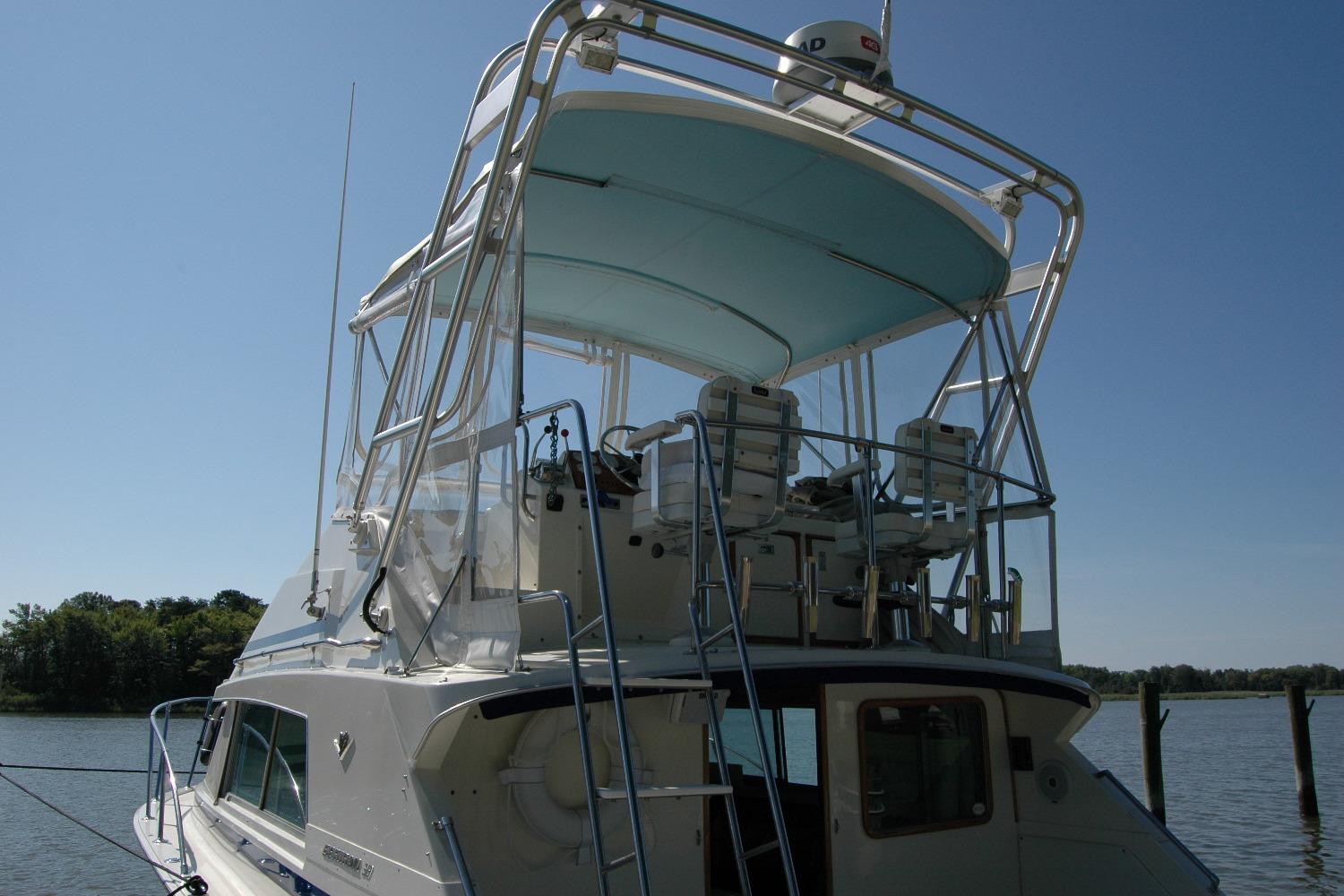 1987 Bertram 33 Sport Fisherman boat with elevated helm, docked on a sunny day.