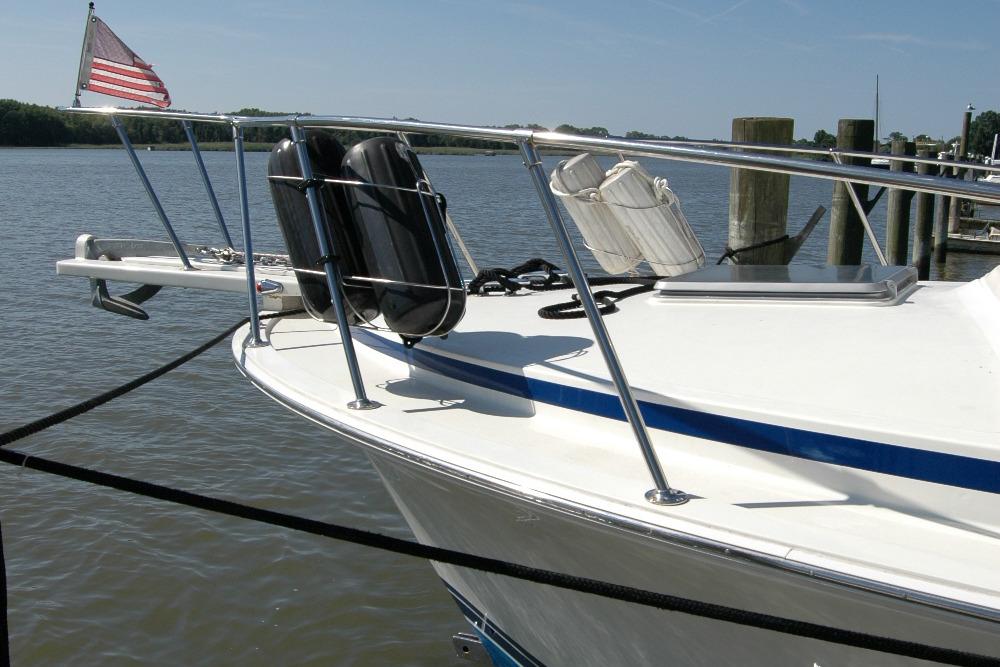 1987 Bertram 33 Sport Fisherman boat docked, featuring American flag and safety equipment.
