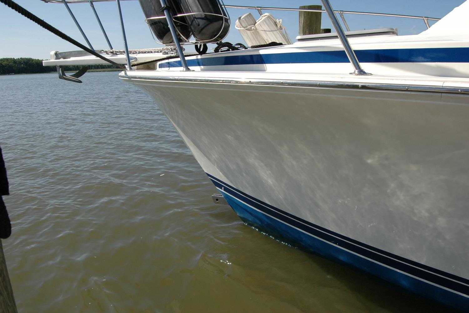 1987 Bertram 33 Sport Fisherman boat docked on calm water.