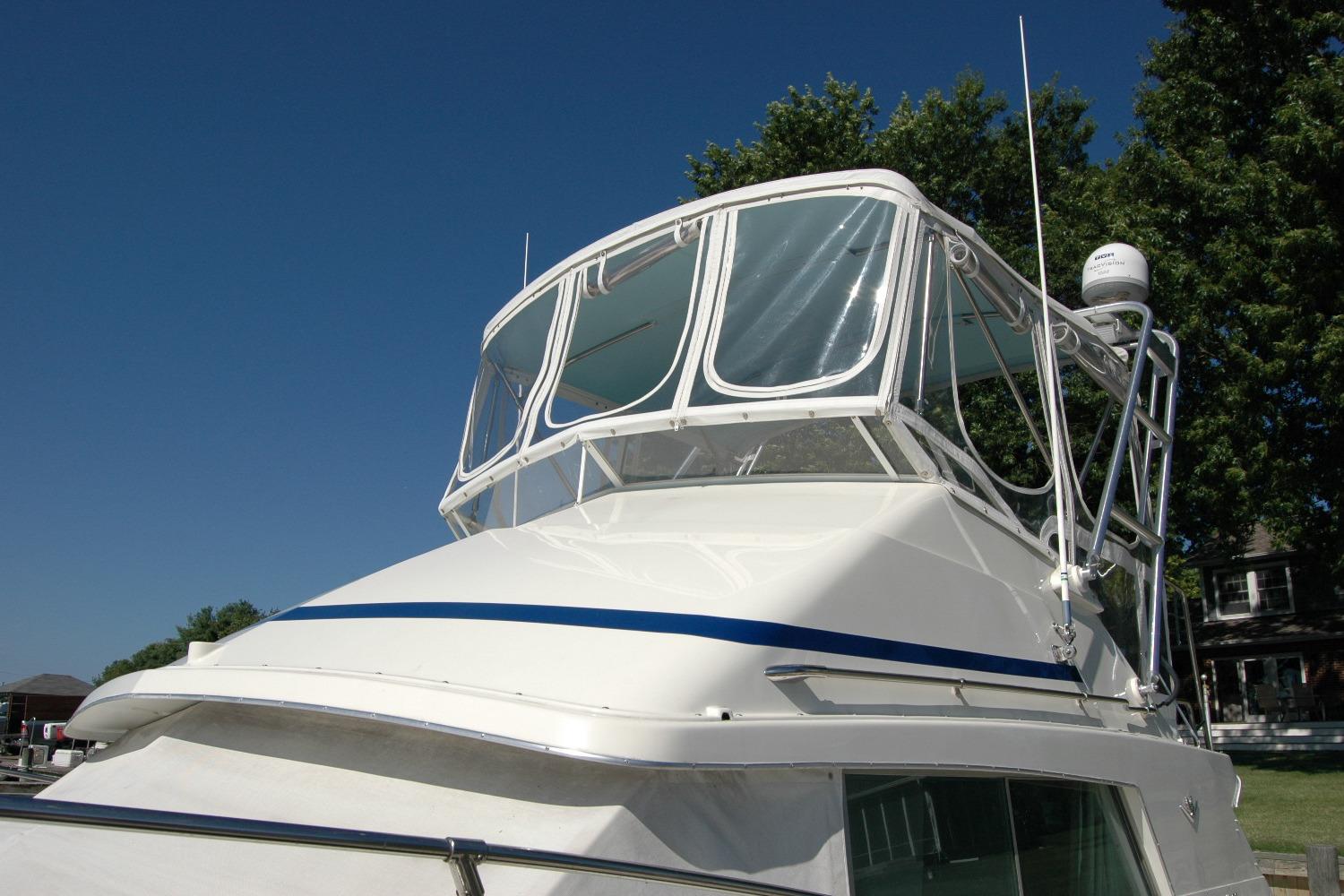 1987 Bertram 33 Sport Fisherman boat with clear blue sky background.