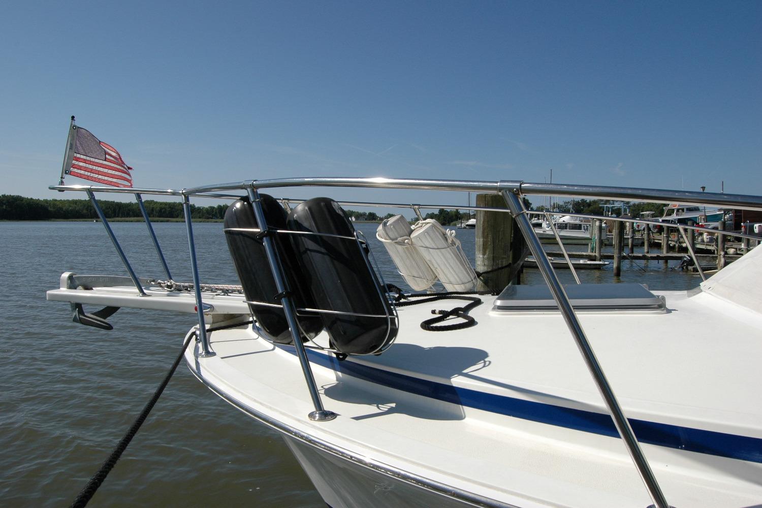 1987 Bertram 33 Sport Fisherman boat docked with American flag, sunny day.