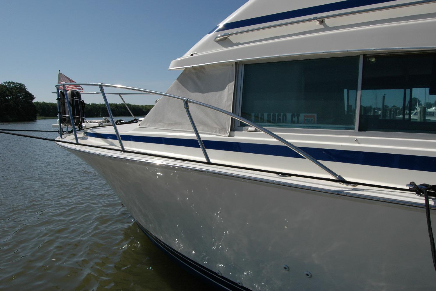 1987 Bertram 33 Sport Fisherman boat docked on calm water.