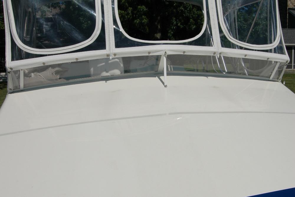 1987 Bertram 33 Sport Fisherman boat with clear windshield and white deck.