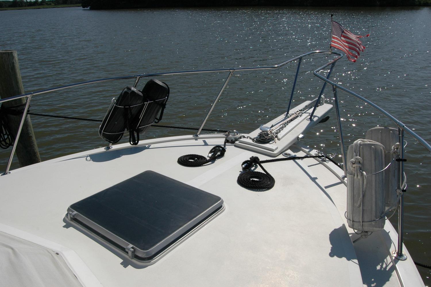 1987 Bertram 33 Sport Fisherman boat deck with American flag and water view.