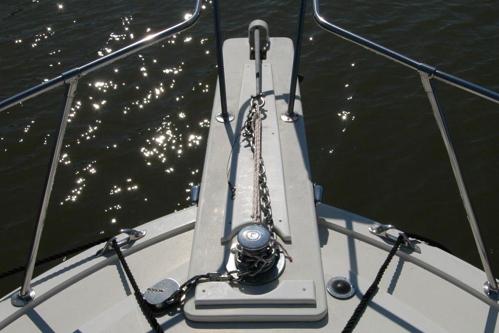 Bow of 1987 Bertram 33 Sport Fisherman with anchor chain, glistening water.