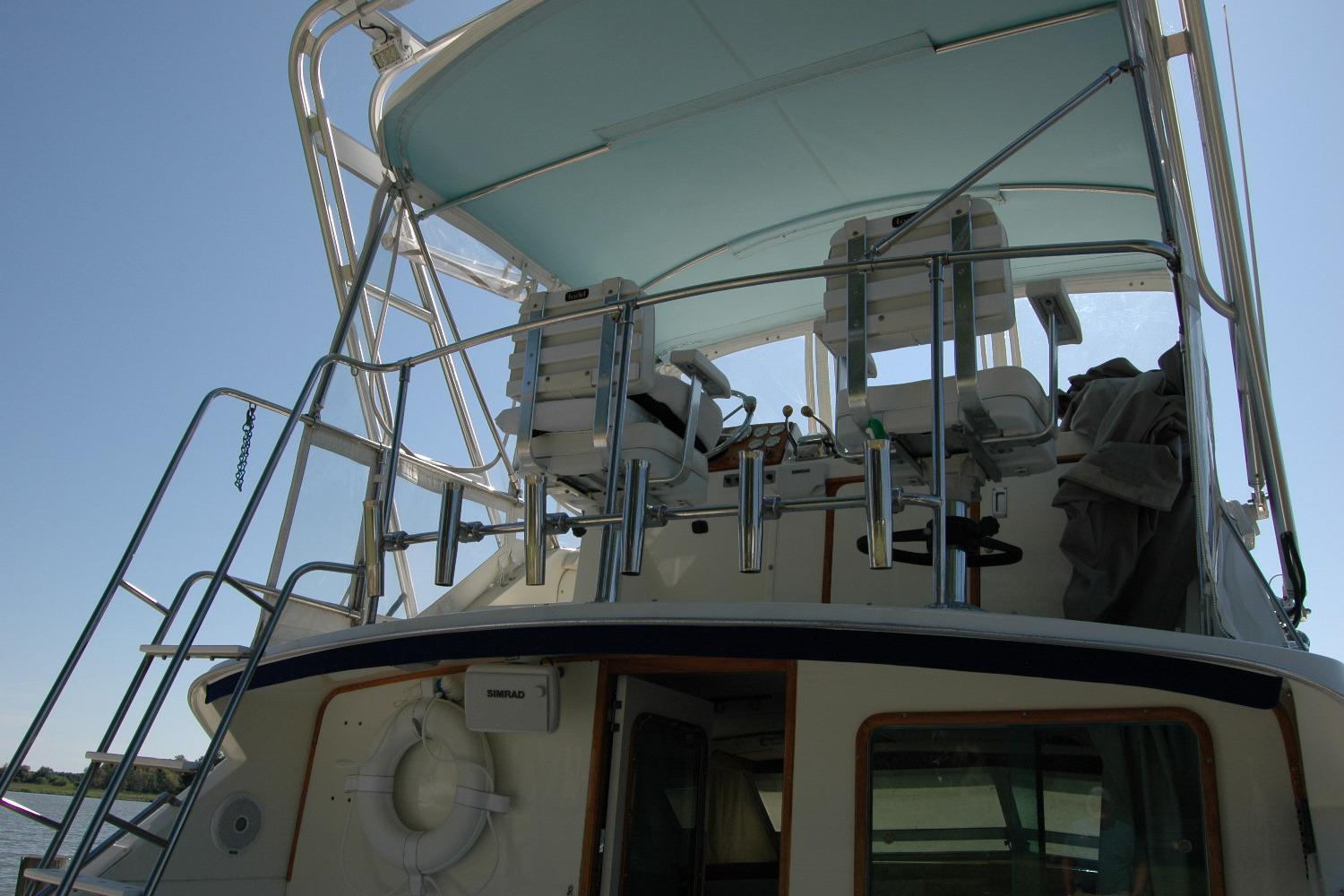 1987 Bertram 33 Sport Fisherman boat with upper deck and seating area.