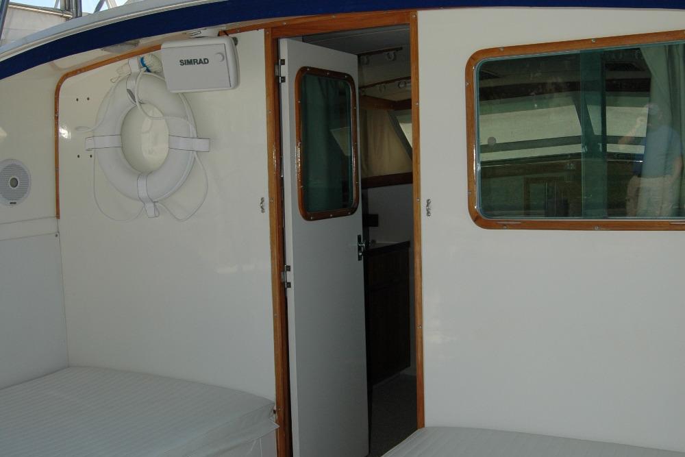 1987 Bertram 33 Sport Fisherman interior with life preserver and open cabin door.