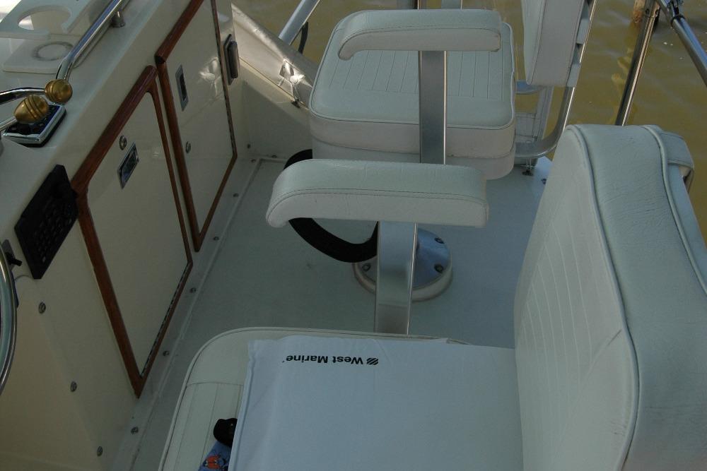 1987 Bertram 33 Sport Fisherman cockpit with white seating and control panel.