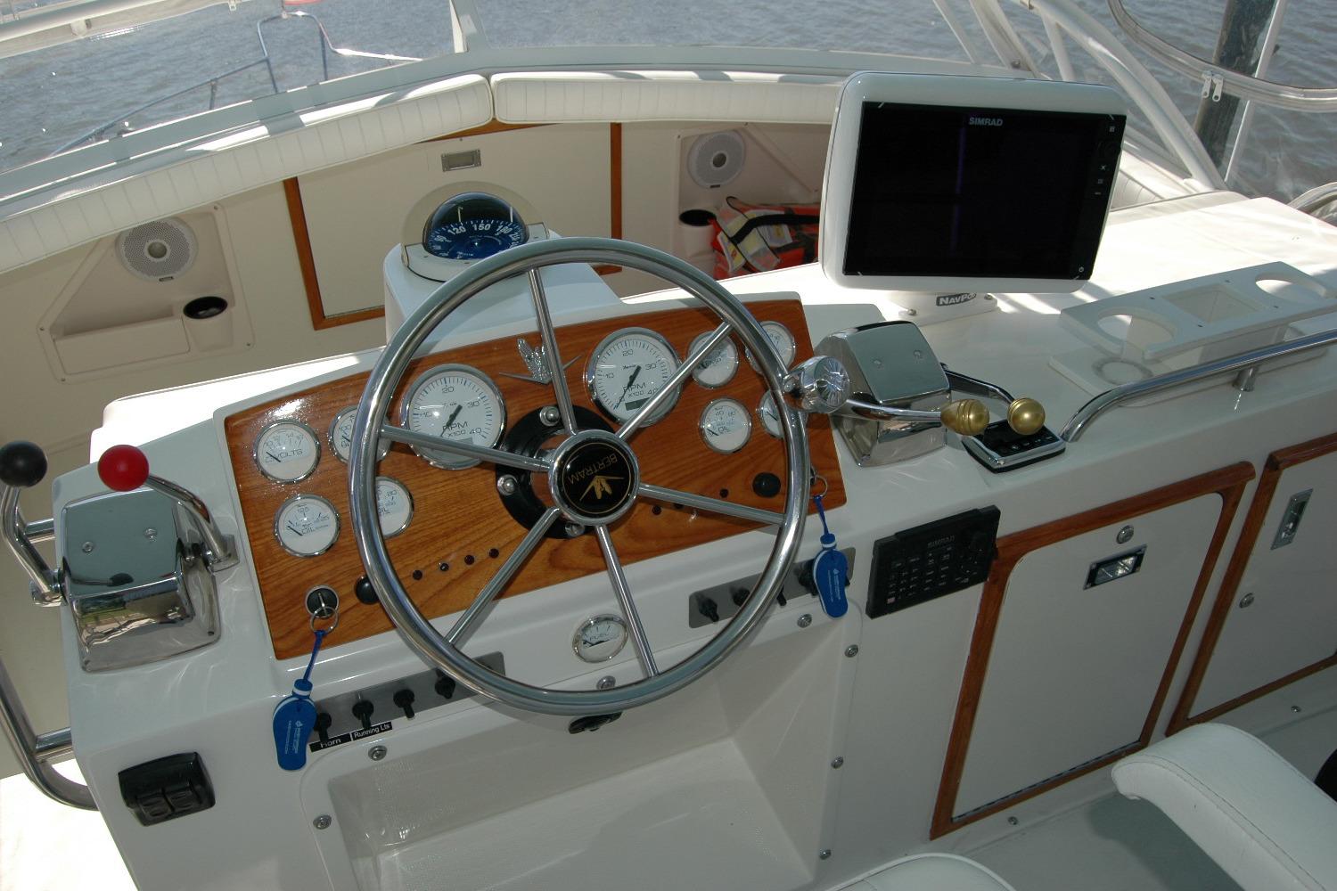 1987 Bertram 33 Sport Fisherman helm with steering wheel, gauges, and navigation equipment.