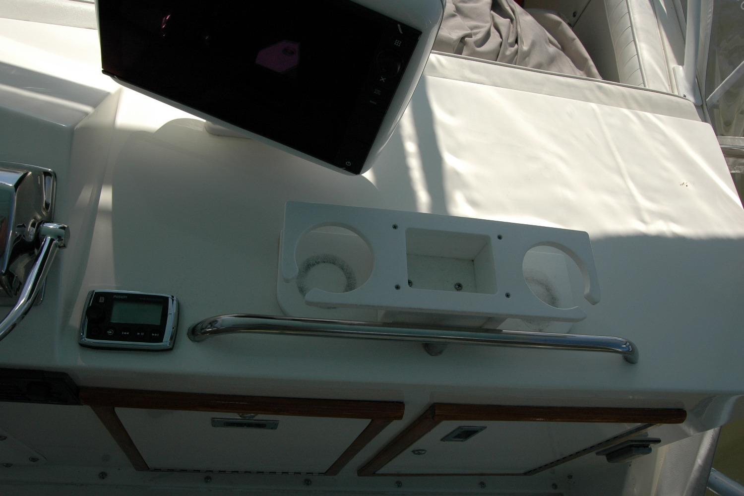 Control panel of a 1987 Bertram 33 Sport Fisherman boat with cup holders.