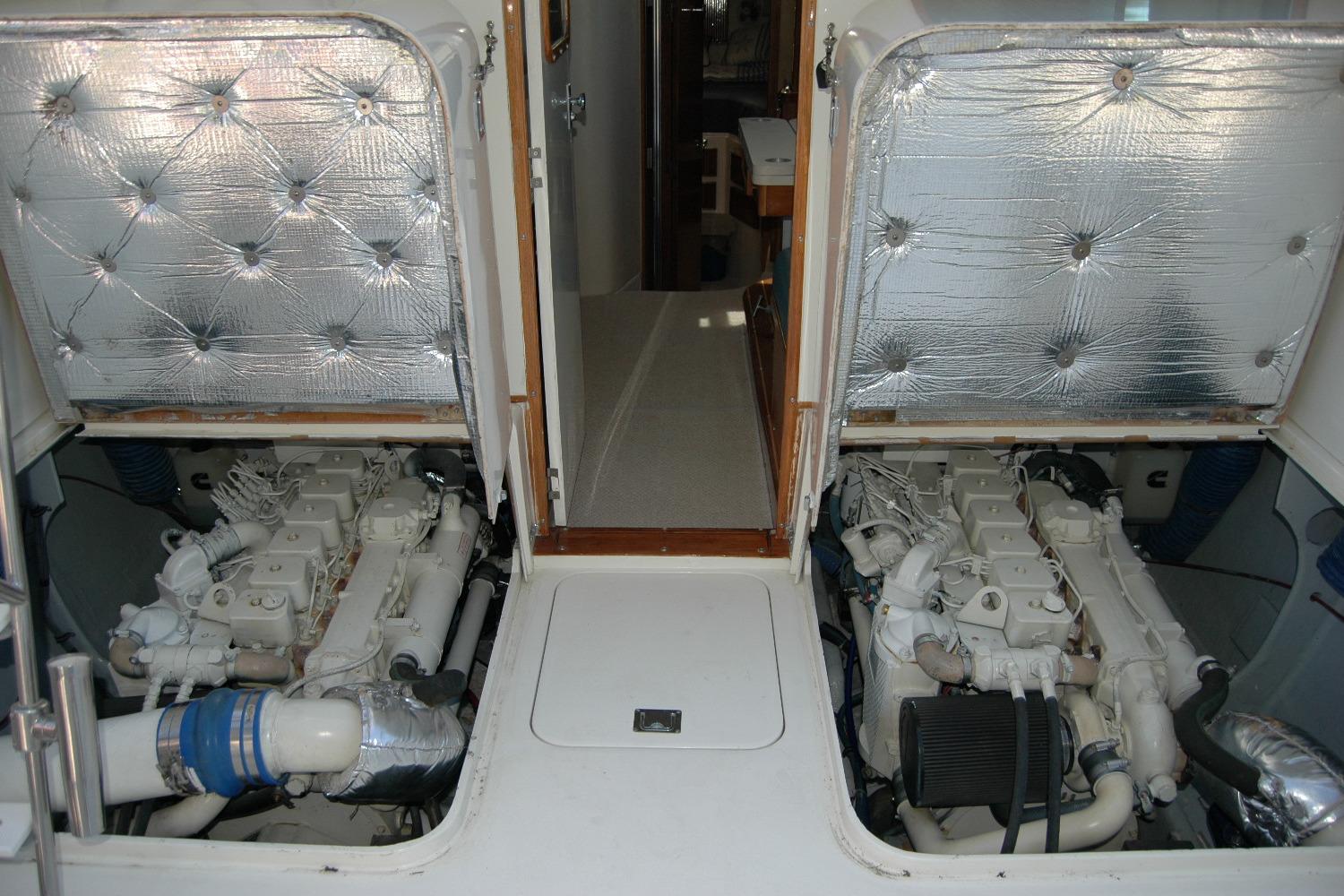 Engine compartment of 1987 Bertram 33 Sport Fisherman with dual engines and insulated covers.