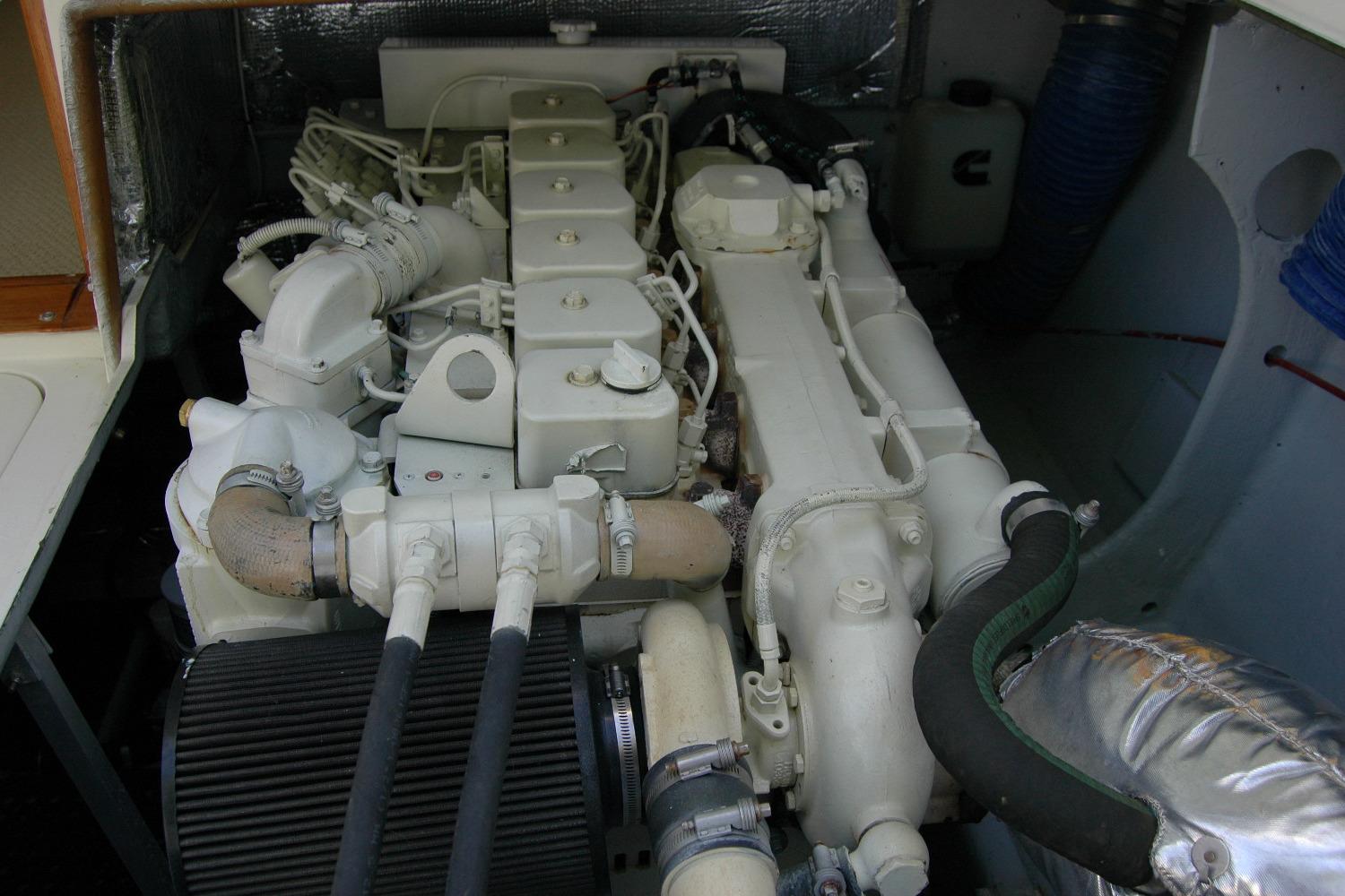 Engine compartment of a 1987 Bertram 33 Sport Fisherman boat, showcasing detailed machinery.