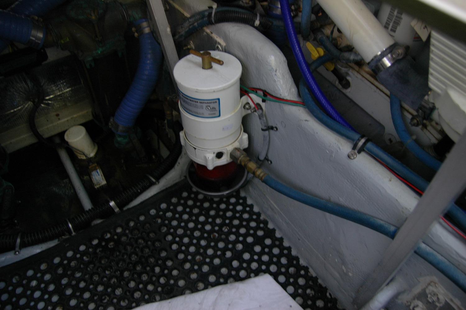 Engine compartment of 1987 Bertram 33 Sport Fisherman with visible fuel filter and hoses.