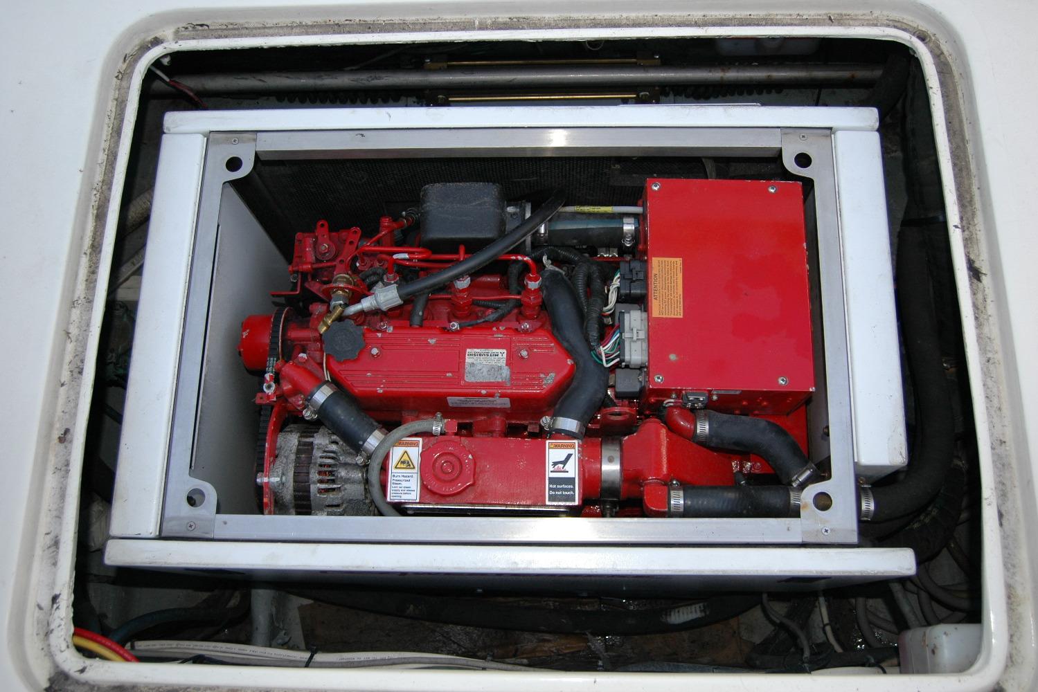 Engine compartment of a 1987 Bertram 33 Sport Fisherman boat, featuring a red engine.