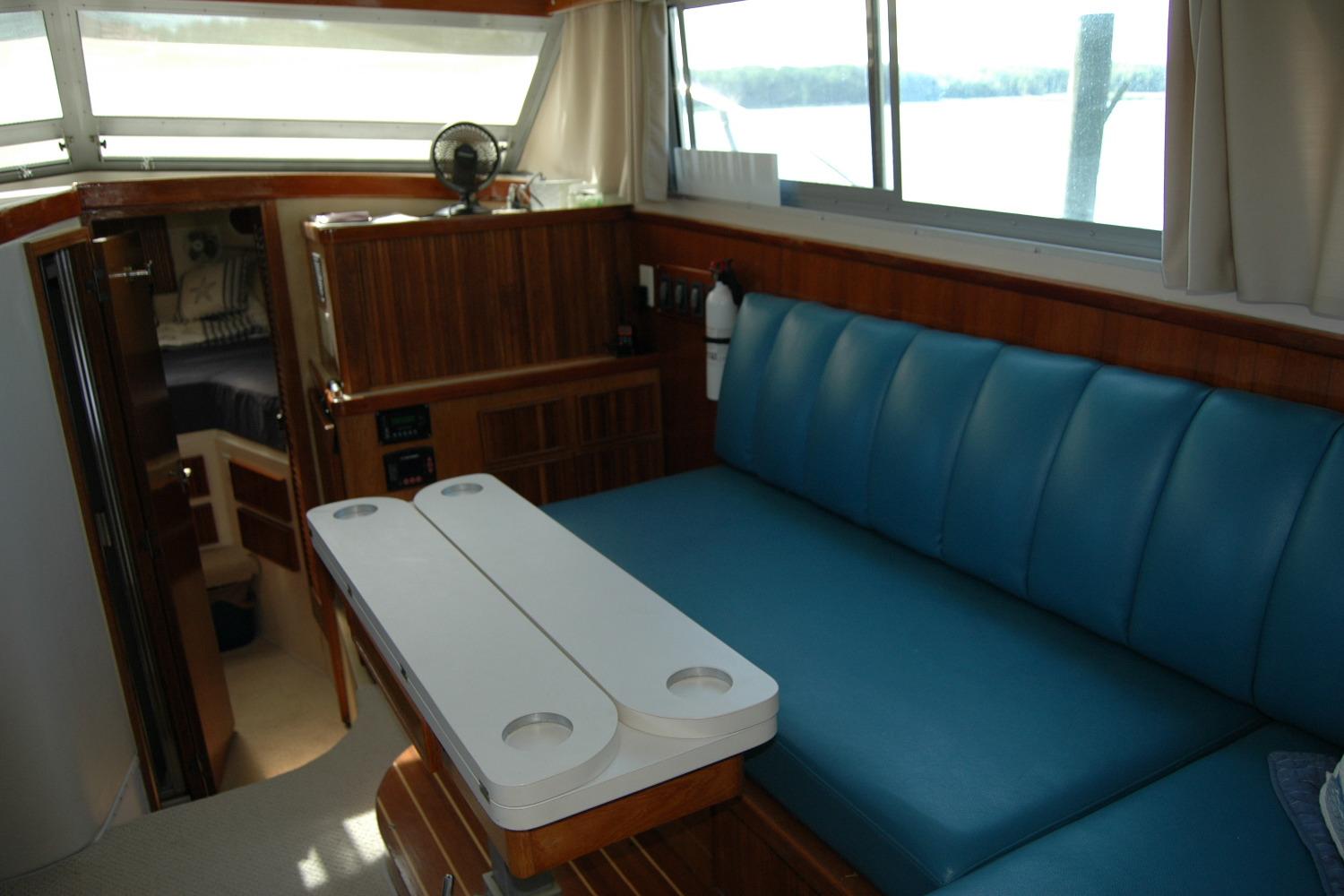 Interior of 1987 Bertram 33 Sport Fisherman with blue seating and wooden accents.