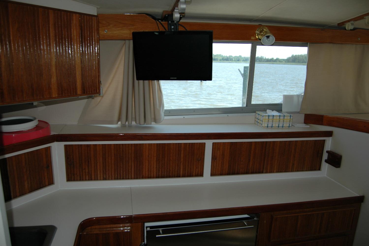 Interior of 1987 Bertram 33 Sport Fisherman with wood cabinets and window view.