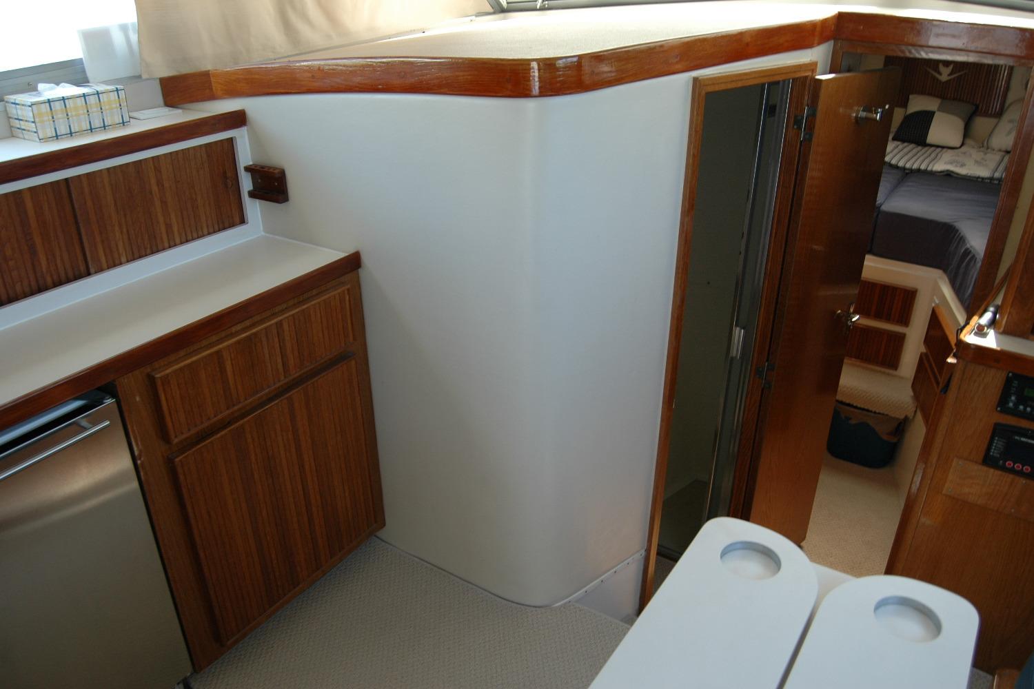 Interior of 1987 Bertram 33 Sport Fisherman with wood cabinetry and cozy sleeping area.
