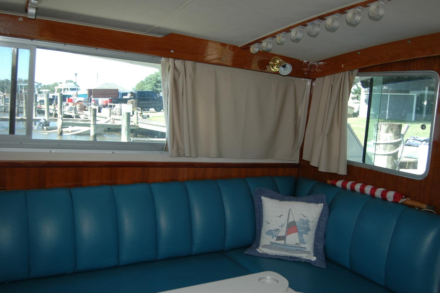 Interior of 1987 Bertram 33 Sport Fisherman with blue seating and nautical decor.
