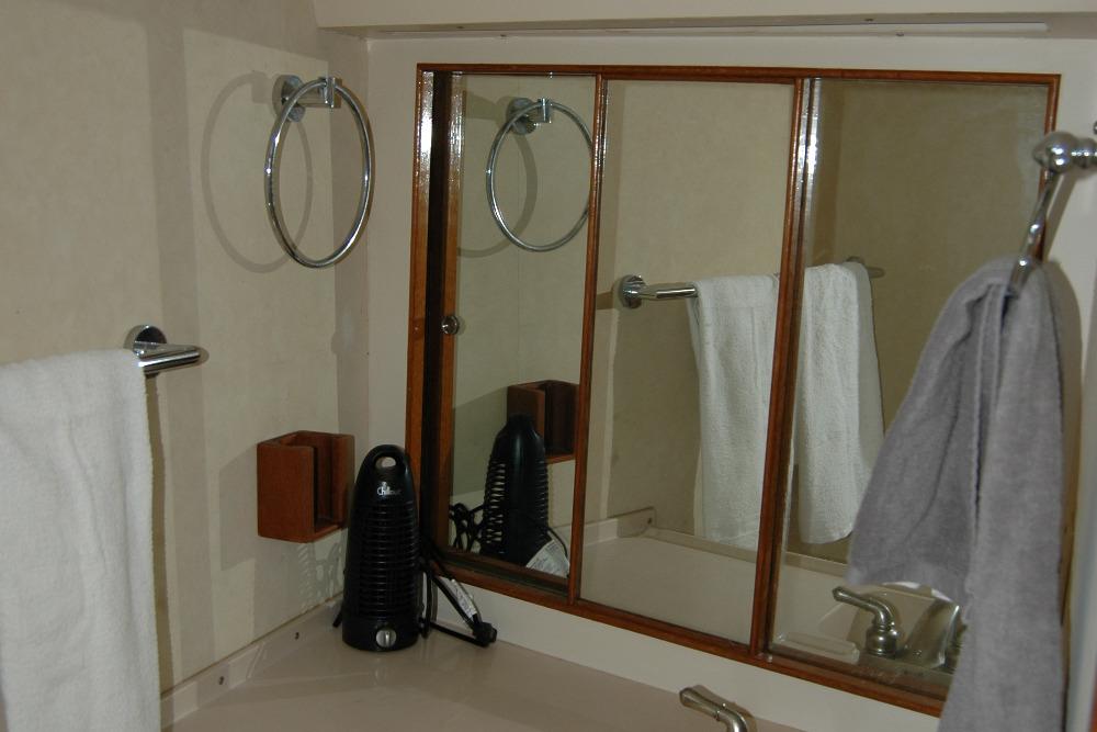 Bathroom interior of 1987 Bertram 33 Sport Fisherman with mirror and towels.