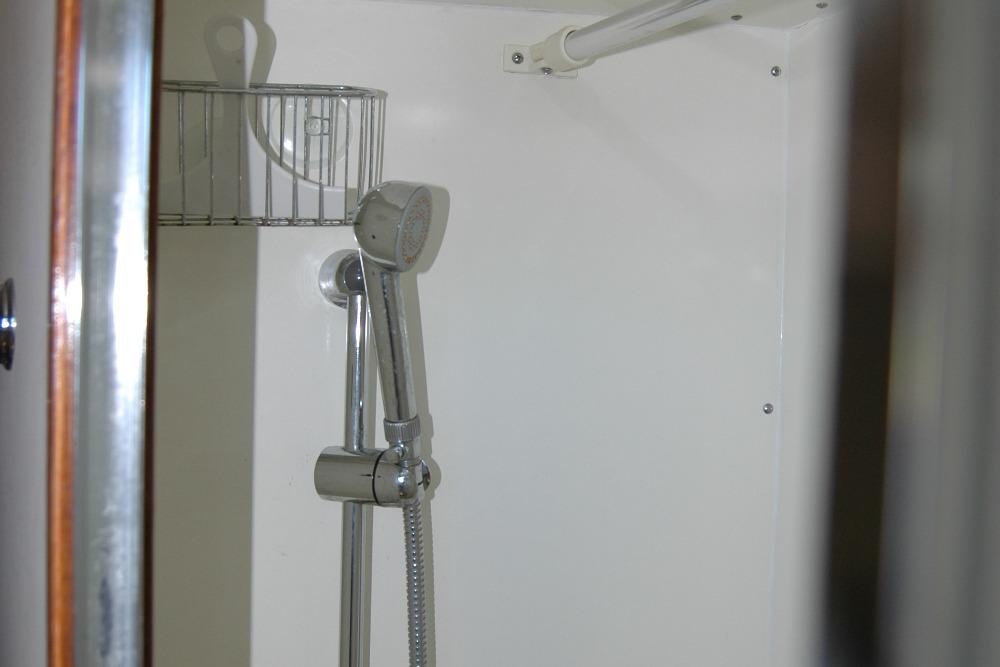 Shower area in 1987 Bertram 33 Sport Fisherman boat, featuring chrome fixtures.