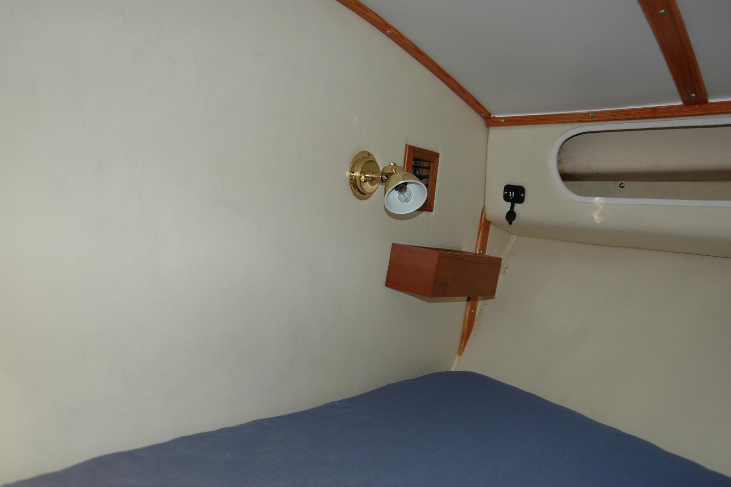 Interior cabin of 1987 Bertram 33 Sport Fisherman with wall lamp and shelf.