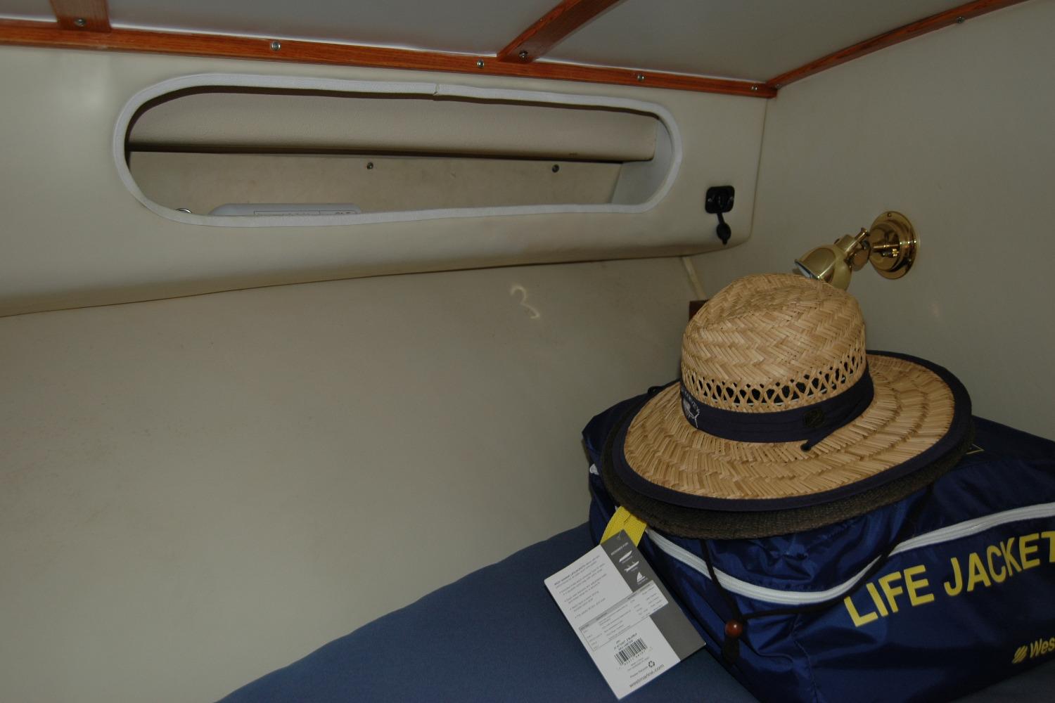 1987 Bertram 33 Sport Fisherman cabin interior with straw hat and life jacket.