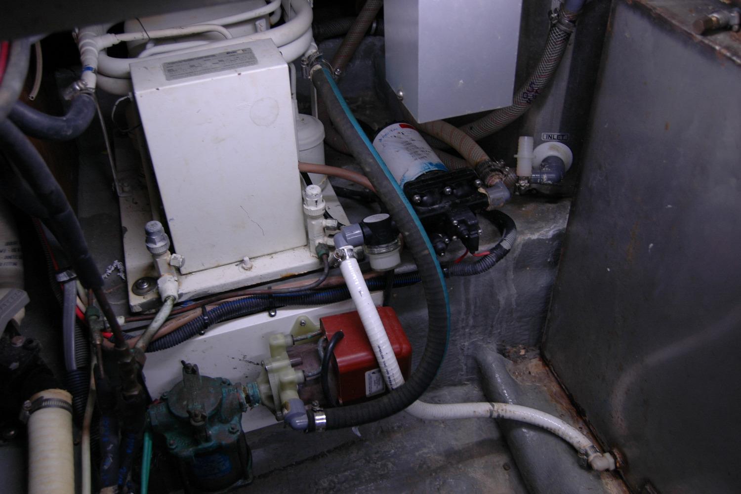 Engine room of 1987 Bertram 33 Sport Fisherman with various mechanical components and wiring.