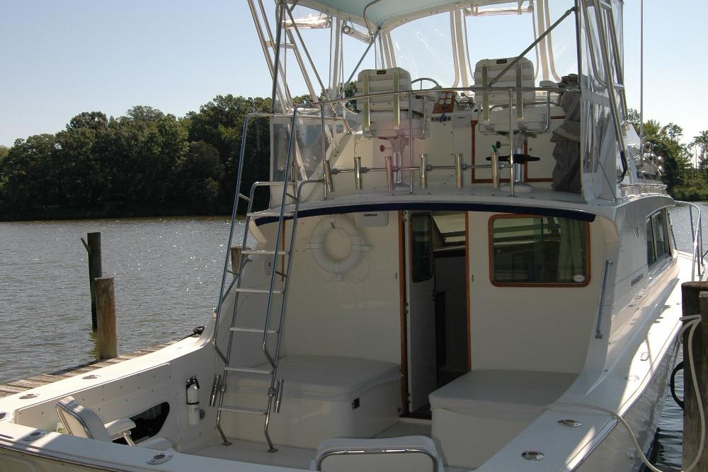 1987 Bertram 33 Sport Fisherman docked, featuring spacious deck and flybridge.