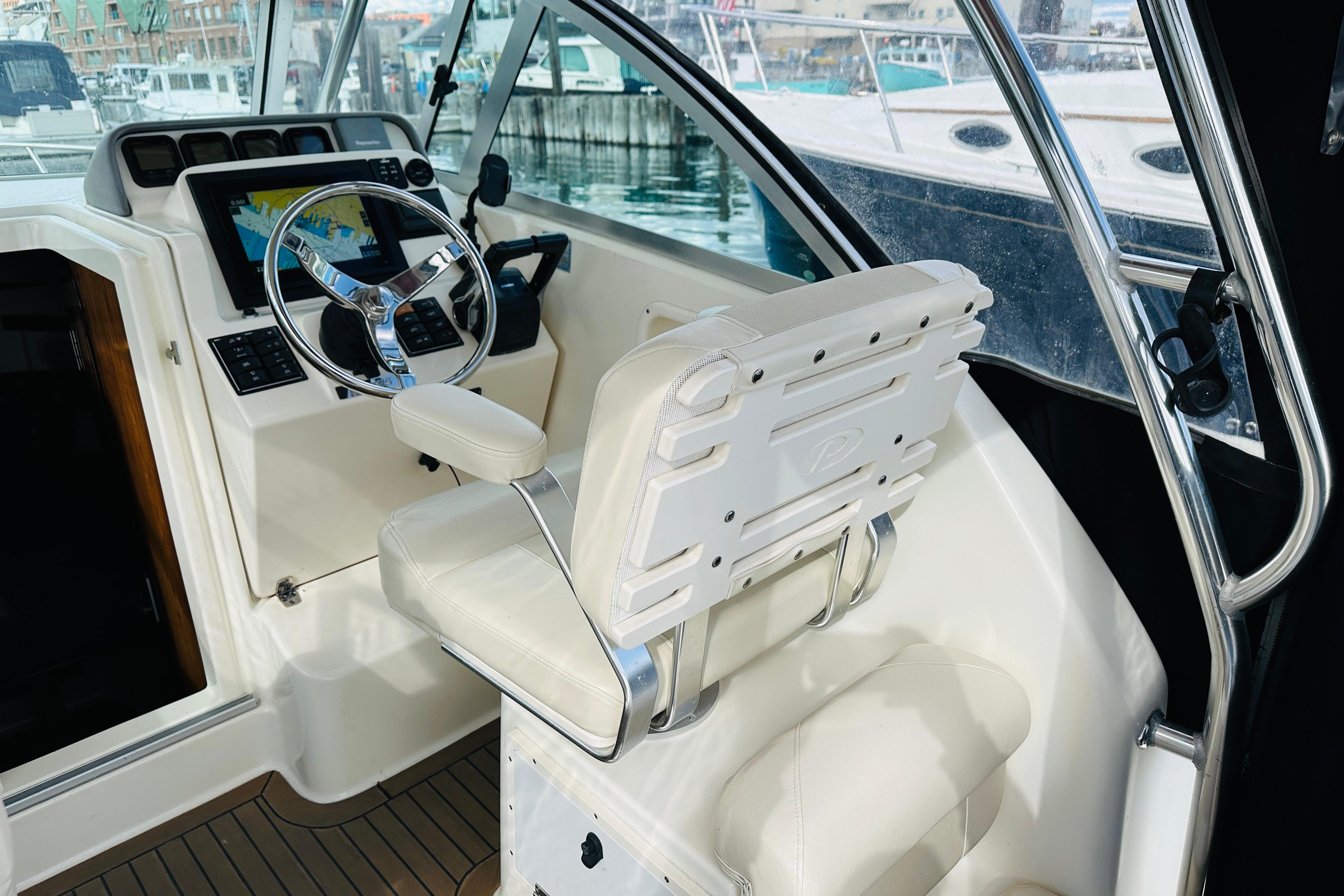 2007 Pursuit OS 285 Offshore boat cockpit with steering wheel and navigation display.