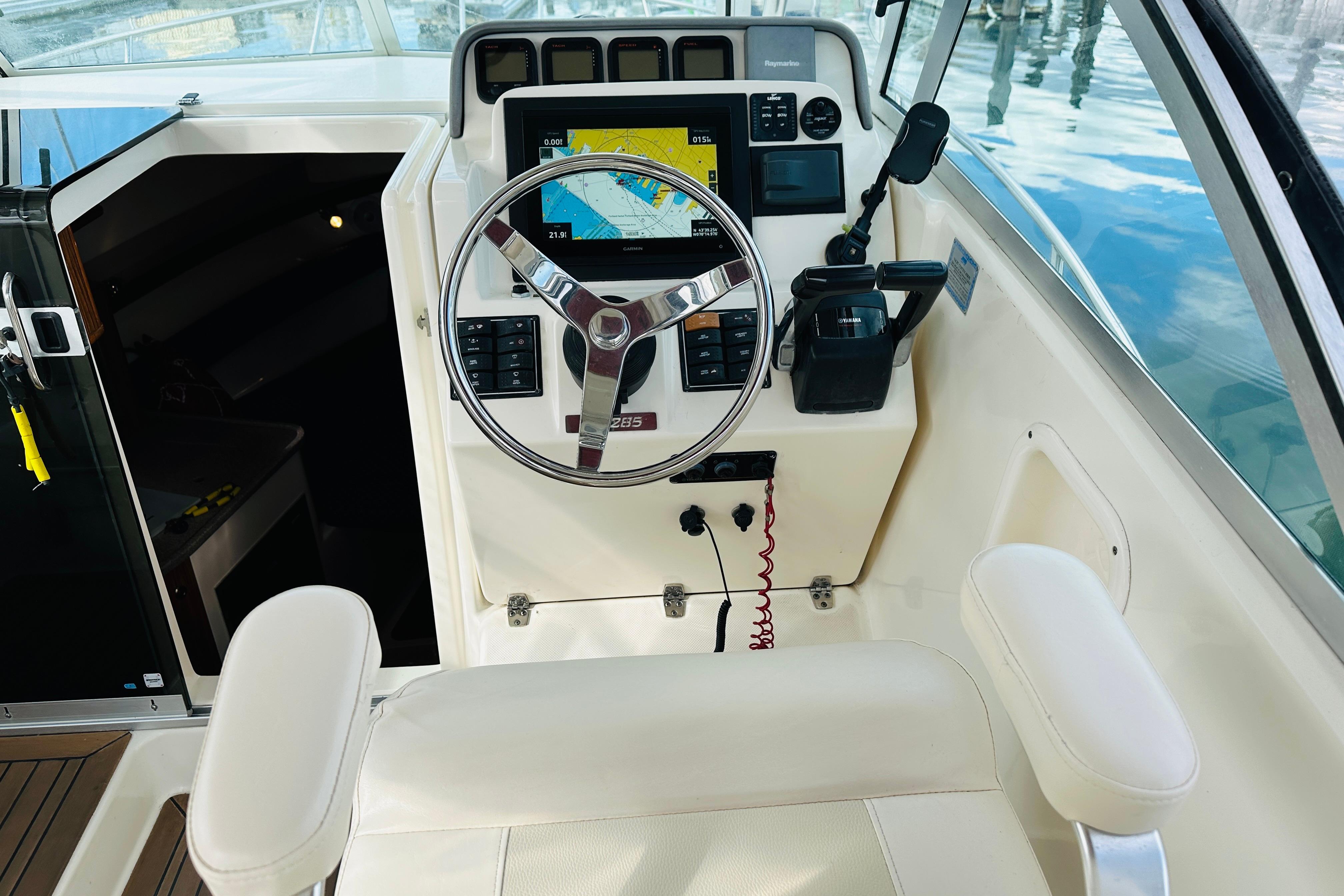 2007 Pursuit OS 285 Offshore boat helm with steering wheel and navigation display.